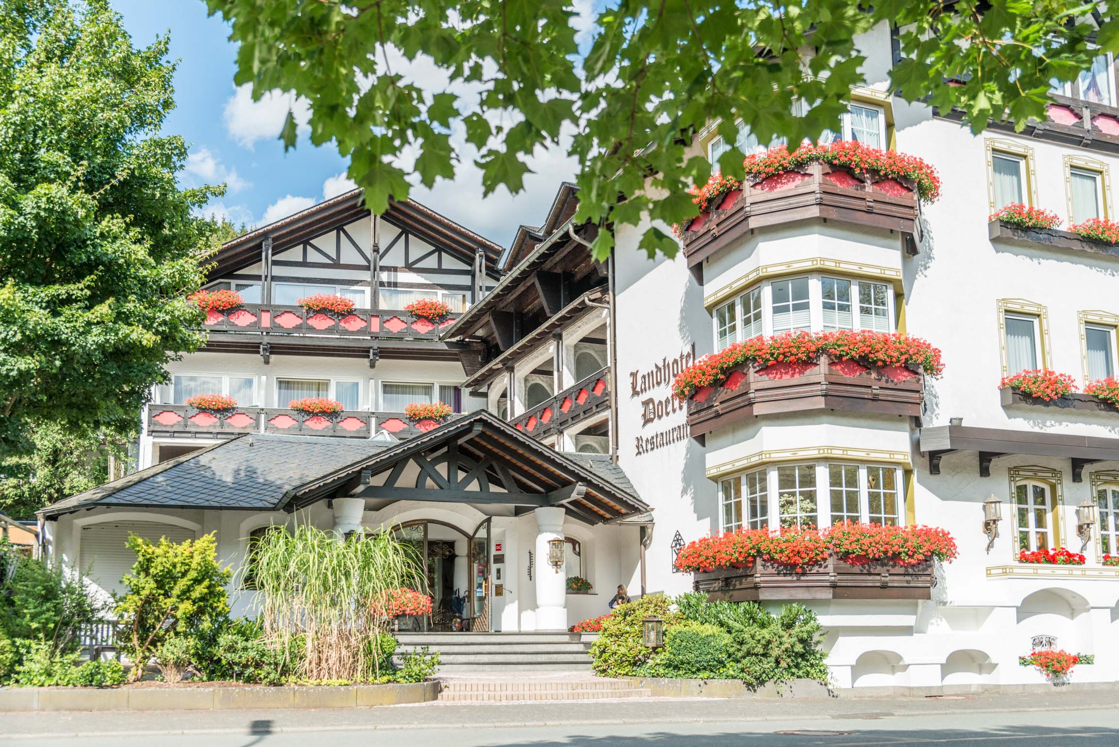 Außenfassade mit Geranien geschmückt im Landhotel Doerr