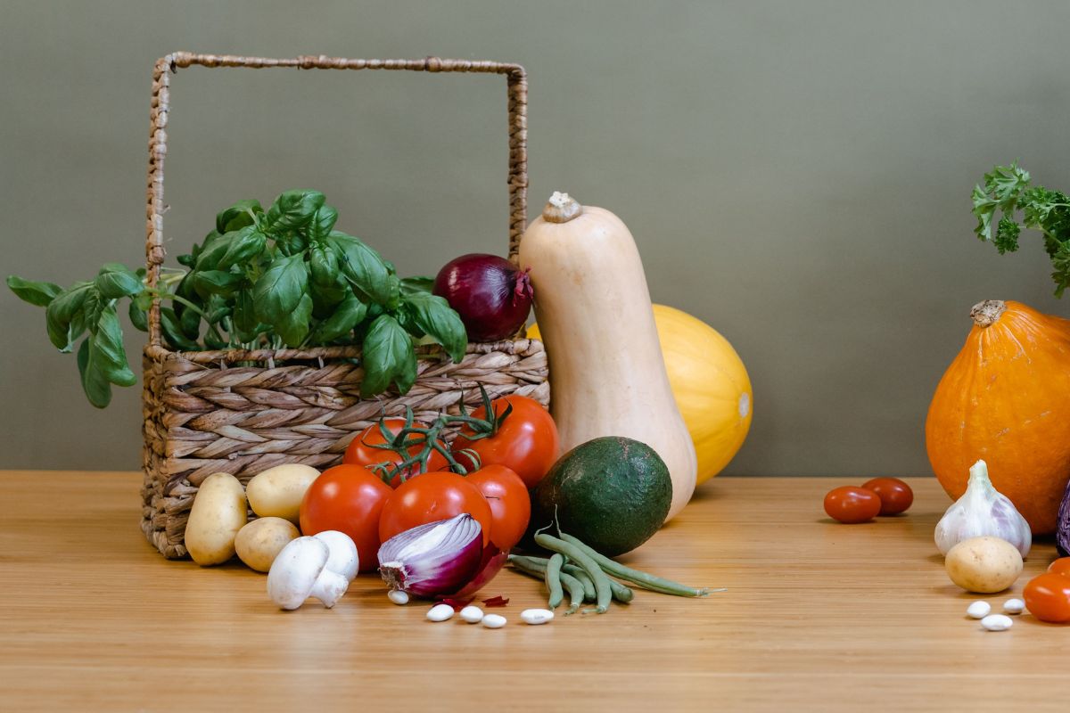Tomaten, Kürbis, Avocado, Zwiebeln, Basilikum in einem Korb