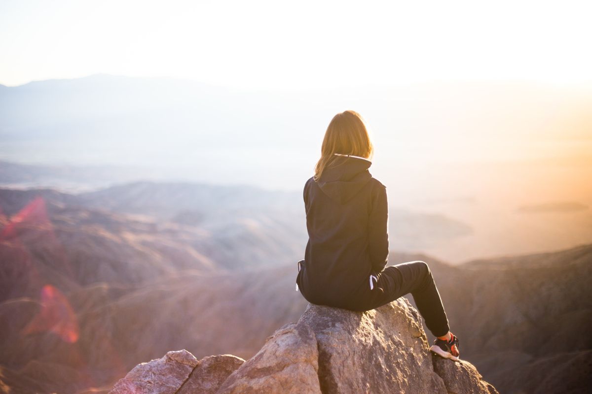 Frau auf Berggipfel, im Sonnenuntergang