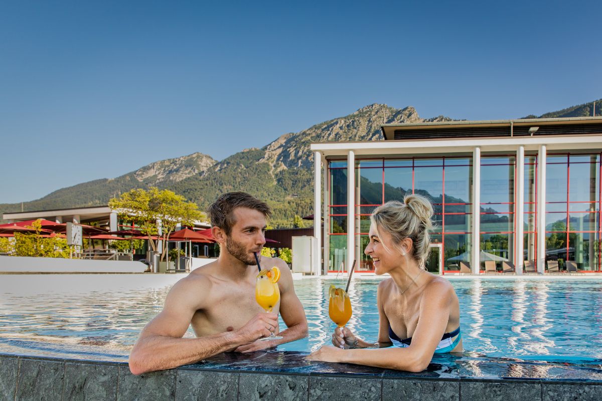 Paar trinkt einen Cocktail am Beckenrand der Rupertus Therme